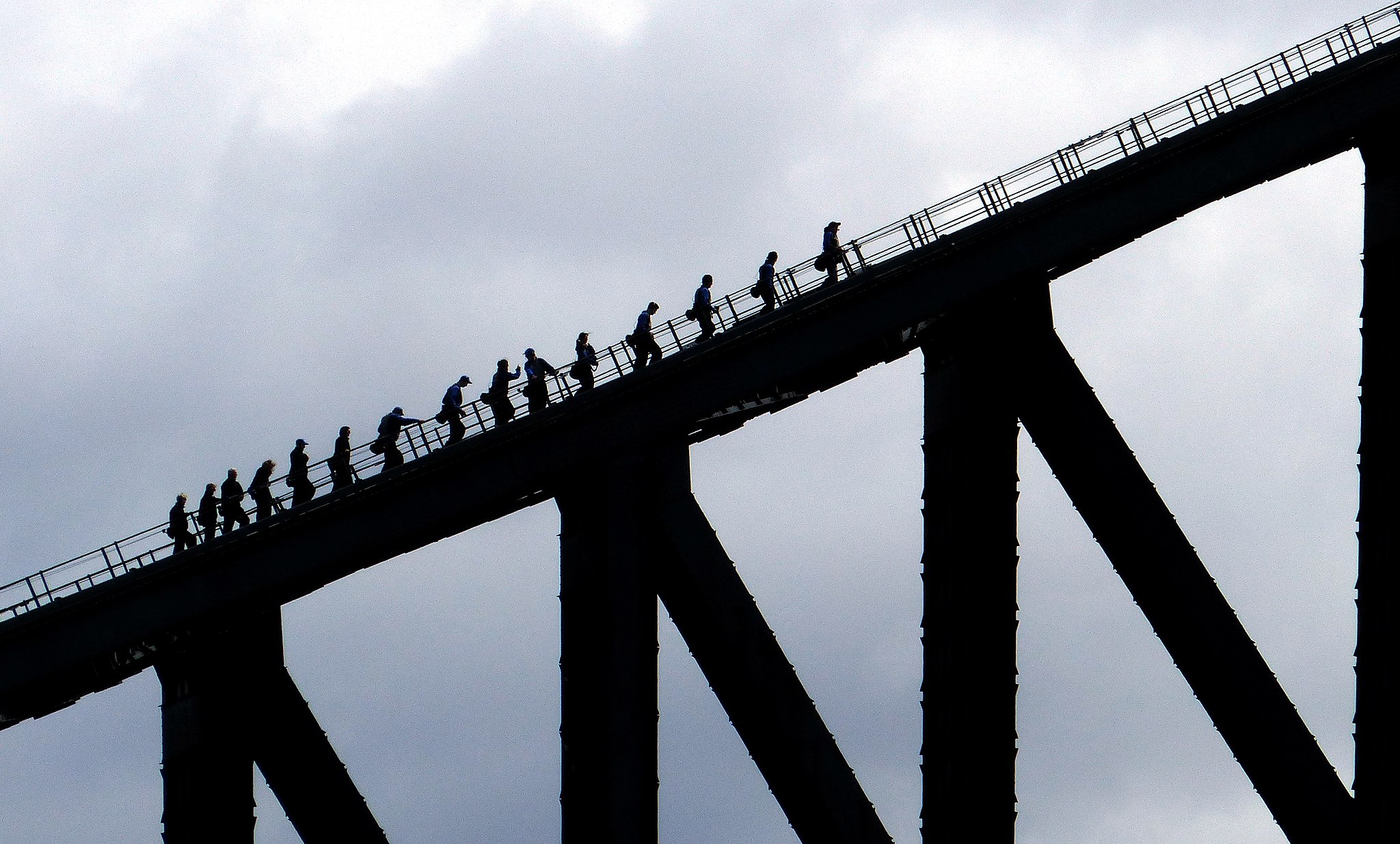 Team of workers climbing a bridge